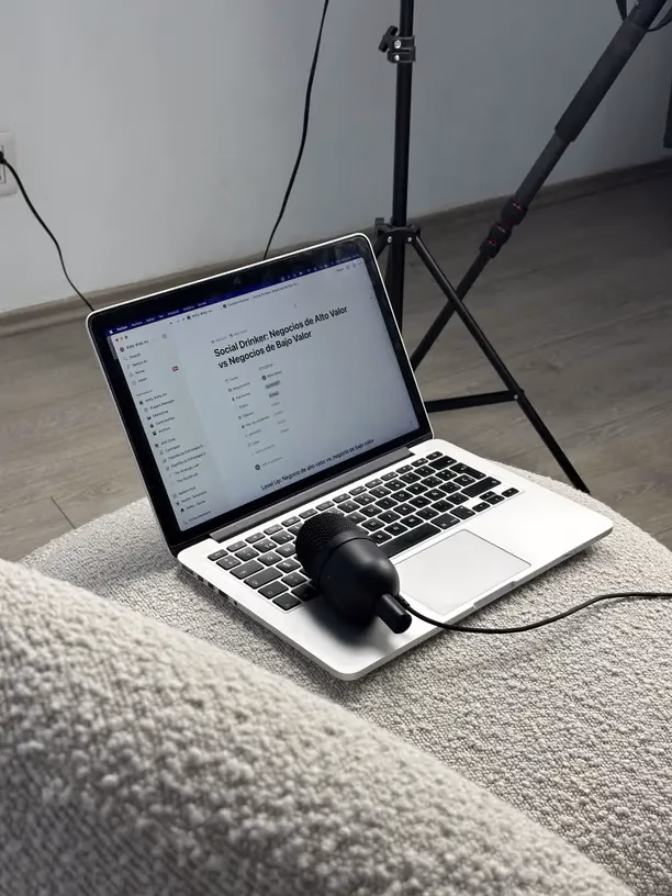 Laptop open with content dashboard, mic in frame, reviewing content plan